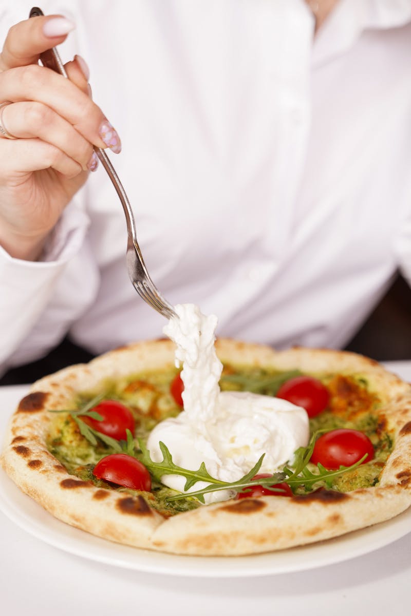 Savor this Italian delight featuring burrata cheese, cherry tomatoes, and fresh arugula on a gourmet pizza.